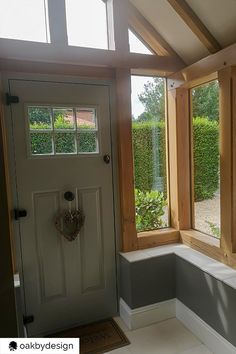 the inside of a house with two windows and a bench in front of it,