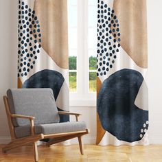 a chair in front of a window with polka dots on it and a curtain behind it