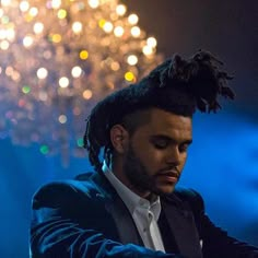 a man with dreadlocks on his head is looking down at something in the distance