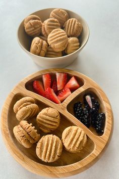 two wooden bowls filled with different types of food on top of a white table next to each other