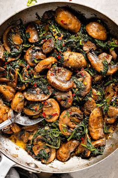 a skillet filled with mushrooms and spinach