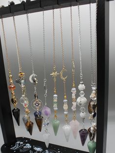 The power of personalized energy with our exquisite Custom Crystal Pendulum. Crafted with precision and intention, each pendulum is a unique masterpiece tailored to your desires. Whether you seek clarity, guidance, or alignment, this bespoke tool is designed to resonate with your energy and amplify your intentions. Our skilled artisans hand-select each crystal, ensuring the highest quality and vibrational resonance. From soothing Amethyst to empowering Tiger Eye, our wide selection of crystals allows you to choose the perfect stone that aligns with your intentions and energy. Personalize your pendulum further with Pendant or design, making it a truly one-of-a-kind treasure. Our customization options add a touch of personal magic to your pendulum. Harness the ancient wisdom of divination an Spiritual Crystal Necklace With Adjustable Chain And Dangle, Wicca Crystals, Dowsing Pendulum, Pendulum Dowsing, Crystal Pendulum, Crystal Angels, Witch Jewelry, Crystal Crafts, Crystal Suncatchers