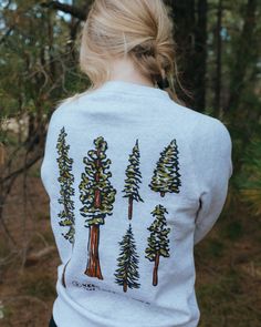 This pullover is an ode to the quiet giants of the forest. Trees’ canopies provide shade & protection - and they also happen to be some of the best eye candy around! The wild just wouldn't be the same without them. Slow down and take time to notice conifers in this comfy pullover. Regular fit (size up for a more relaxed fit) Midweight Ultra comfy anti-pilling fleece (80% Cotton/ 20% Poly blend) Preshrunk to minimize shrinkage We’re not your average outdoor brand... together we pick up one pound Mountain Sweatshirt Design, Nature Streetwear, Hiking Hoodie, Mountain Sweater, Outdoorsy Style, Retreat Ideas, Forest Trees, One Pound, Just Peachy