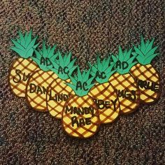 three pineapples with words on them sitting on the carpet