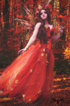 a woman dressed as a fairy standing in the woods