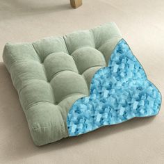 a green and blue cushion on the floor