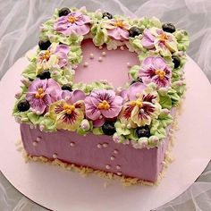 a heart shaped cake decorated with flowers on a plate