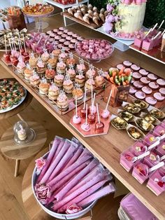 a table filled with lots of different types of desserts and cupcakes on sticks