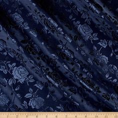 a blue fabric with white flowers on it and a ruler in the foreground,