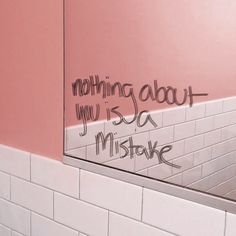 a bathroom mirror with graffiti written on it