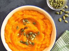 a bowl of mashed sweet potatoes topped with pumpkin seeds