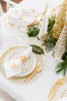 the table is set with gold and white plates