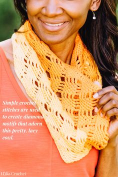 a woman wearing an orange top and yellow shawl smiles at the camera with her hand on her hip