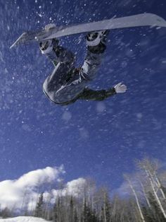 a man flying through the air while riding skis on top of snow covered ground