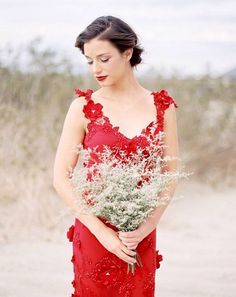 a woman in a red dress holding flowers