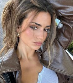 a beautiful woman wearing a brown leather jacket