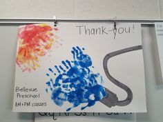 a handprinted thank you sign hangs on the wall in front of a bulletin board