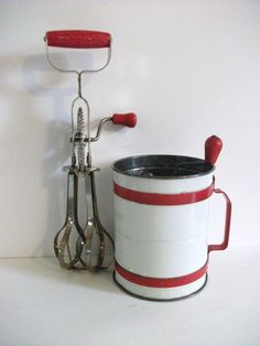 a red and white bucket sitting next to a pair of scissors