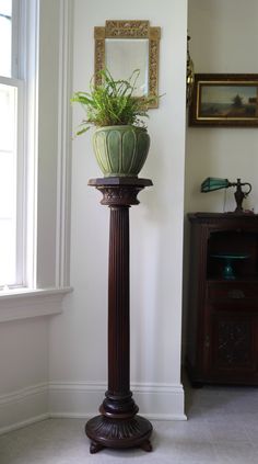 a tall wooden pole with a potted plant on top