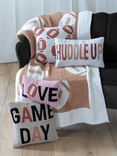 a couch with two pillows on top of it and a pillow that says love game day