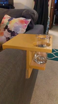 a table with a glass on it in front of a couch