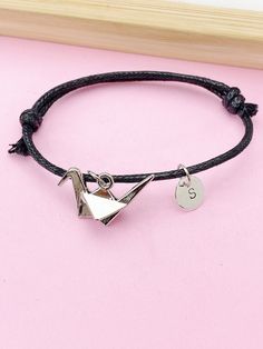 This is a silver-tone origami crane charm with a stainless steel initial charm on a cowhide leather cord bracelet. ♥ You will receive one bracelet. HOW TO ORDER 1) Choose the quantity. 2) Choose the initial in the option or add a note to seller at checkout. 3) Add to the cart. DESCRIPTION ♥ Bracelet, Cowhide Leather Cord Bracelet 7 1/2 with 1 inch extension. ♥ Initial Charms, Stainless Steel, Size: about 8-10mm in diameter, 1mm thick, Nickel Safe, ♥ Crane, Tibetan Style Alloy Pendants, Cadmium F Adjustable Silver Leather Bracelet With Lobster Clasp, Sterling Silver Leather Bracelet For Gift, Silver Sterling Leather Bracelet Gift, Silver Sterling Leather Bracelet As A Gift, Silver Sterling Silver Leather Bracelet As Gift, Silver Leather Bracelet With Sliding Knot As Gift, Adjustable Silver Leather Bracelet Gift, Adjustable Silver Leather Bracelet For Gift, Adjustable Silver Leather Bracelet As Gift