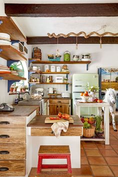 an open kitchen with wooden shelves and tiled flooring