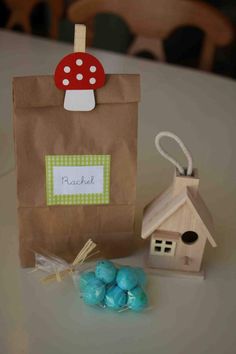 a paper bag with a mushroom on it next to some little houses and blue candies