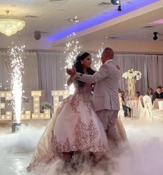 a bride and groom are dancing on the dance floor with sparklers in the air