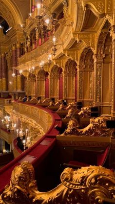 an ornately decorated auditorium with red seats and chandeliers