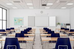 an empty classroom with desks and chairs in front of a whiteboard on the wall