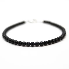 "Black Onyx beads are hand strung to form this classic single strand bracelet. The beads are tiny measuring about 3.0mm. This is a beautifully tiny, and delicate onyx bracelet. You could wear this alone or stack with other bracelets for a layering effect. I have hand strung these beads using a premium beading wire that has beautiful drape and it fastens with a sterling silver or gold filled lobster clasp. The bracelet is available in 6.0\" to 8.0\" lengths. Select your size at check out. Matchin Classic Black Beaded Bracelets As Gift, Minimalist Onyx Beaded Bracelets With Round Beads, Minimalist Onyx Beaded Bracelet With Round Beads, Everyday Single Strand Bracelet With Round Beads, Minimalist Onyx Beaded Bracelet, Classic Onyx Beaded Bracelets With Adjustable Fit, Minimalist Single Strand Beaded Bracelets With Round Beads, Classic Adjustable Single Strand Beaded Bracelets, Classic Black Beaded Bracelets For Everyday