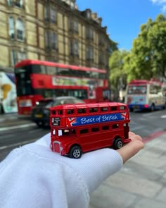 a red double decker bus driving down a street