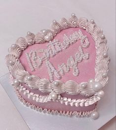 a heart shaped birthday cake with pearls on the edges and congratulations written in white frosting