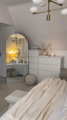 a bedroom with a bed, dresser and mirror on the wall next to an arched doorway