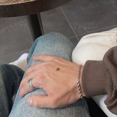 a person with their hand on the leg of another persons lap