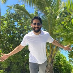 a man standing on a skateboard in front of some trees