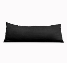 a black pillow sitting on top of a white wall