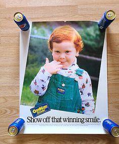 a photo of a young boy with two sodas on it and the caption show off that winning smile