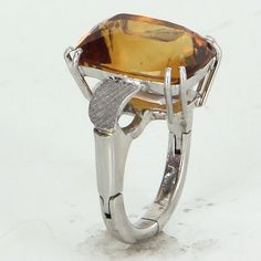 "Vintage citrine cocktail ring (circa 1960s), crafted in 14 karat white gold and 950 platinum. Cushion cut citrine measures 15.5mm x 12mm (estimated at 9.22 carats). The citrine is in excellent condition and free of cracks or chips. The ring is fitted with an arthritic band (can be removed if desired). The ring is in excellent original condition. Particulars: Weight: 11.7 grams Stones: Cushion cut citrine measures 15.5mm x 12mm (estimated at 9.22 carats). The citrine is in excellent condition an Formal Art Deco White Gold Topaz Ring, Modern Formal Hallmarked Topaz Ring, Modern Topaz Ring With Polished Finish, Formal Topaz Ring With Polished Finish, Formal Sterling Silver Topaz Ring With Polished Finish, Modern Citrine Rings For Formal Occasions, Silver Topaz Ring With Polished Finish For Formal Occasions, Formal Silver Topaz Ring With Polished Finish, Modern Sterling Silver Topaz Ring For Formal Occasions