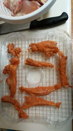 some chicken pieces are sitting on a plastic tray