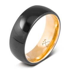 a black and gold wedding band with the cross engraved on it's center ring