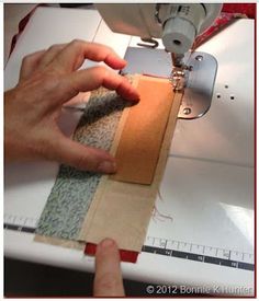 someone is using a sewing machine to sew fabric on the side of a piece of cloth