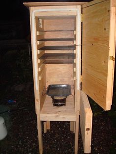 a wooden cabinet with an open door on the outside and shelves in front of it