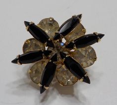 Vintage faux black onyx & rhinestone brooch. Gold tone metal brooch is 1" x 1" with a standard working fastener. Faux black onyx faceted navettes & clear round rhinestones, all of which are present and intact. Excellent condition. Black Brooch Pins For Evening, Vintage Black Collectible Brooches, Vintage Black Brooch Lapel Pin, Vintage Black Party Pins, Metal Brooch, Rhinestone Brooches, Gold Tone Metal, Black Onyx, Prong Setting