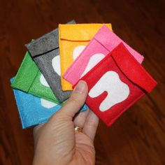 a person is holding four different colored pieces of cloth with the letter q on them