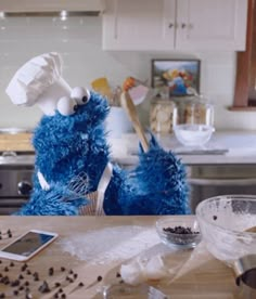 two sesame street characters are in the kitchen making cookies and other things on the counter