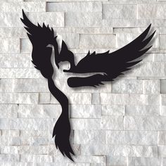 a black and white photo of a bird on a brick wall with it's wings spread out