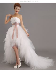 the woman is wearing a white dress with a pink sash