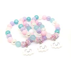 These adorable bracelets are the perfect favor for your little one's cloud themed party! Each bracelet features a resin cloud charm, resin rhinestone beads and an assortment of light pink, light blue, light purple and white 10mm acrylic beads strung with durable stretch floss cord. Each bracelet comes individually packaged in organza bags. Not quite what you are looking for? Request a custom order! I can match your bracelets to your other party decor. To be the first to know about new items, sal Celestial Party, Cloud Birthday, Diy Kandi, Birthday Bracelet, Cute Bracelets, Rhinestone Bead, Bead Stringing, Purple And White, Pink Light